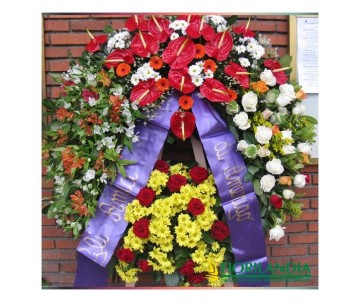 Corona funebre con fiori dai toni caldi